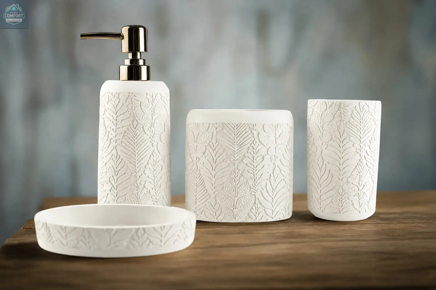 White embossed leaf pattern bathroom accessories set with soap dispenser, toothbrush holder, tumbler, and soap dish on countertop