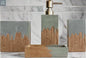 Gray and wood bathroom accessories set styled on bathroom counter with decorative plant and soap dispenser