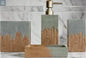Gray and wood bathroom accessories set styled on bathroom counter with decorative plant and soap dispenser
