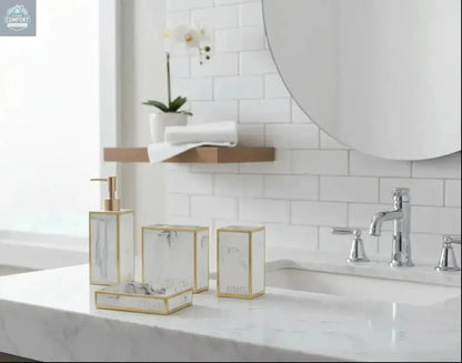 White marble bathroom accessories set with gold trim including soap dispenser, toothbrush holder, tumbler, and soap dish
