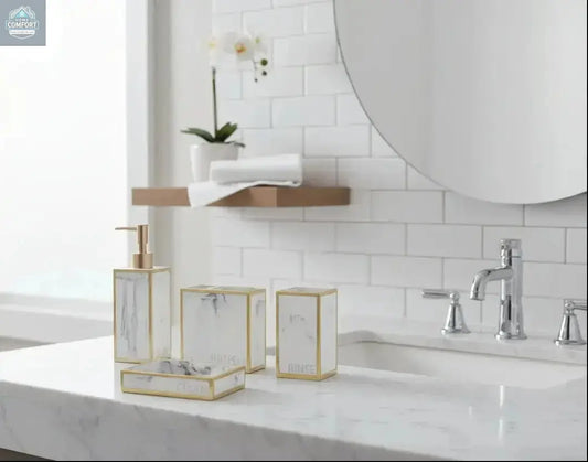 White marble bathroom accessories set with gold trim including soap dispenser, toothbrush holder, tumbler, and soap dish