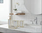 White marble bathroom accessories set with gold trim including soap dispenser, toothbrush holder, tumbler, and soap dish