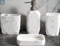 White marble textured bathroom accessories set with soap dispenser, toothbrush holder, tumbler, and soap dish on counter