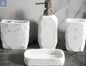 White marble textured bathroom accessories set with soap dispenser, toothbrush holder, tumbler, and soap dish on counter