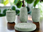 Green patterned bathroom accessories set with soap dispenser, toothbrush holder, tumbler, and soap dish on countertop