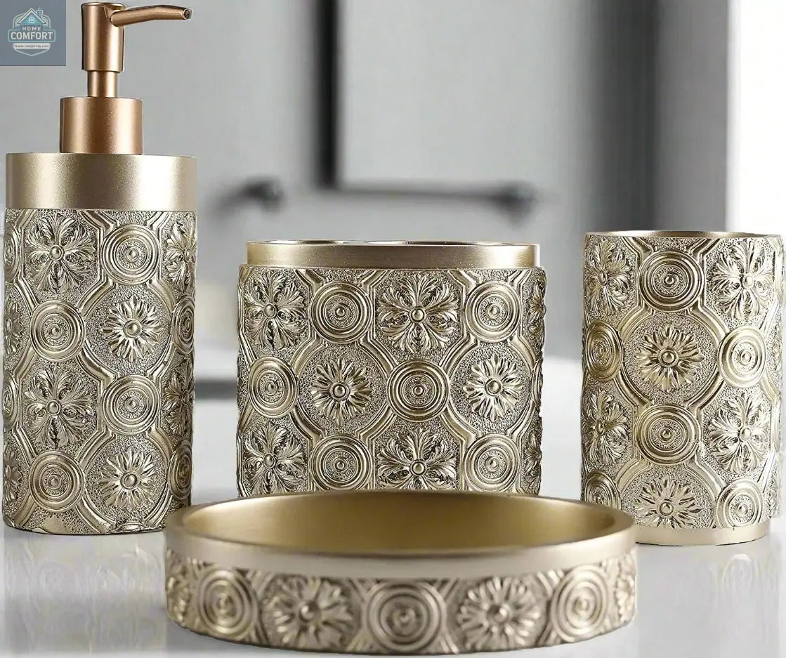Gold ornate patterned bathroom accessories set with soap dispenser, toothbrush holder, tumbler, and soap dish on countertop