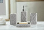 Gray textured stone bathroom accessories set with soap dispenser, toothbrush holder, tumbler, and soap dish on countertop