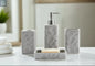 Gray textured stone bathroom accessories set with soap dispenser, toothbrush holder, tumbler, and soap dish on countertop