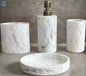 White marble hex pattern bathroom accessories set with soap dispenser, toothbrush holder, tumbler, and soap dish on countertop