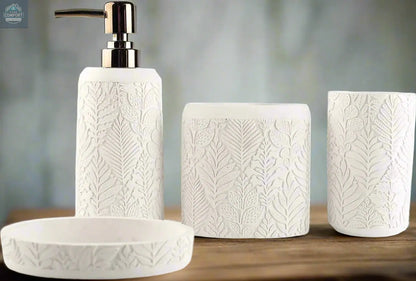 White embossed leaf pattern bathroom accessories set with soap dispenser, toothbrush holder, tumbler, and soap dish on countertop