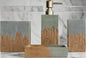 Gray and wood bathroom accessories set styled on bathroom counter with decorative plant and soap dispenser