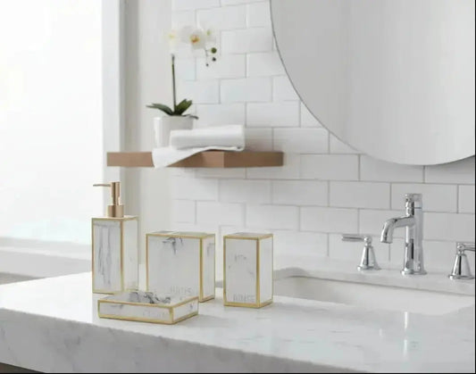 White marble bathroom accessories set with gold trim including soap dispenser, toothbrush holder, tumbler, and soap dish