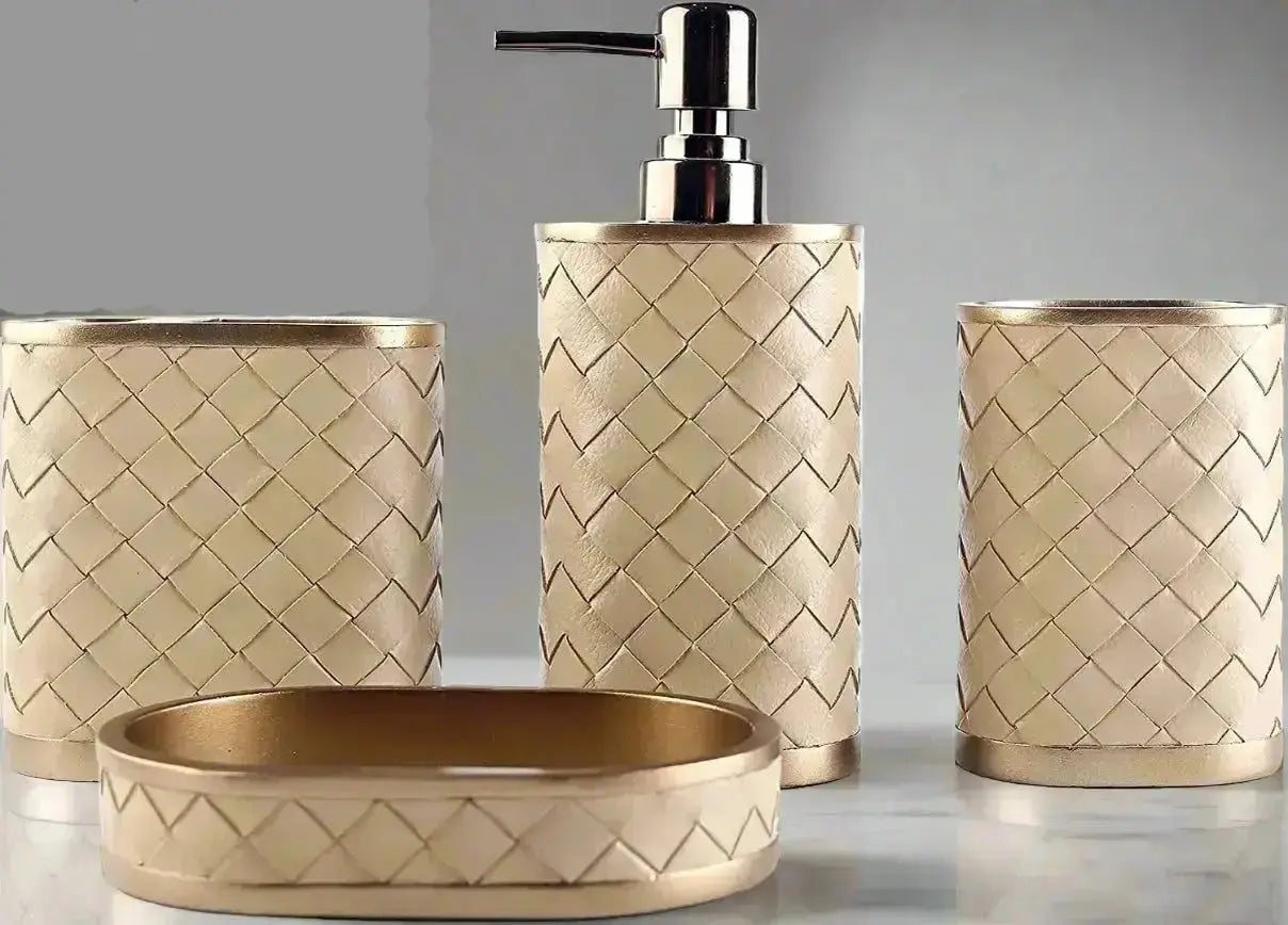 Gold woven bathroom accessories set with soap dispenser, toothbrush holder, tumbler, and soap dish on countertop