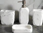White marble textured bathroom accessories set with soap dispenser, toothbrush holder, tumbler, and soap dish on counter