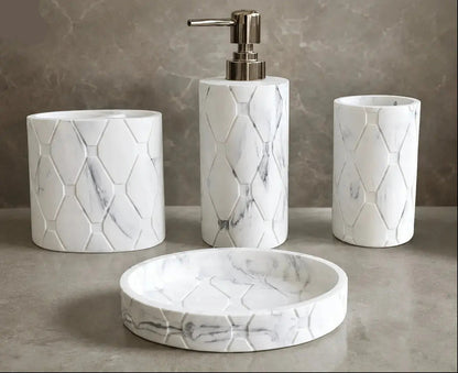 White marble hex pattern bathroom accessories set with soap dispenser, toothbrush holder, tumbler, and soap dish on countertop