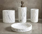 White marble hex pattern bathroom accessories set with soap dispenser, toothbrush holder, tumbler, and soap dish on countertop