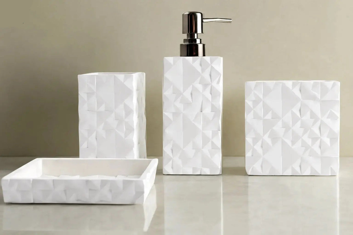 White geometric textured bathroom accessories set with soap dispenser, toothbrush holder, tumbler, and soap dish on countertop