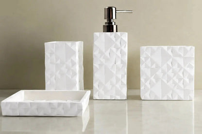 White geometric textured bathroom accessories set with soap dispenser, toothbrush holder, tumbler, and soap dish on countertop