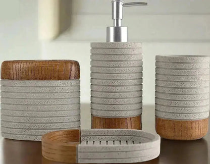 Close up view of gray and wood bathroom accessories set including soap dispenser, tumbler, toothbrush holder, and soap dish