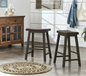 Set of two dark brown wood backless counter stools placed in farmhouse style room