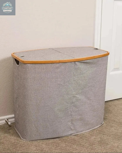 Grey bamboo canvas laundry hamper with lid closed placed in bedroom corner showing compact laundry storage solution
