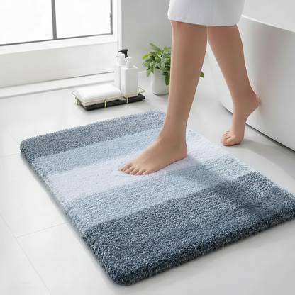 Person stepping onto a gradient bath mat in a bathroom setting.