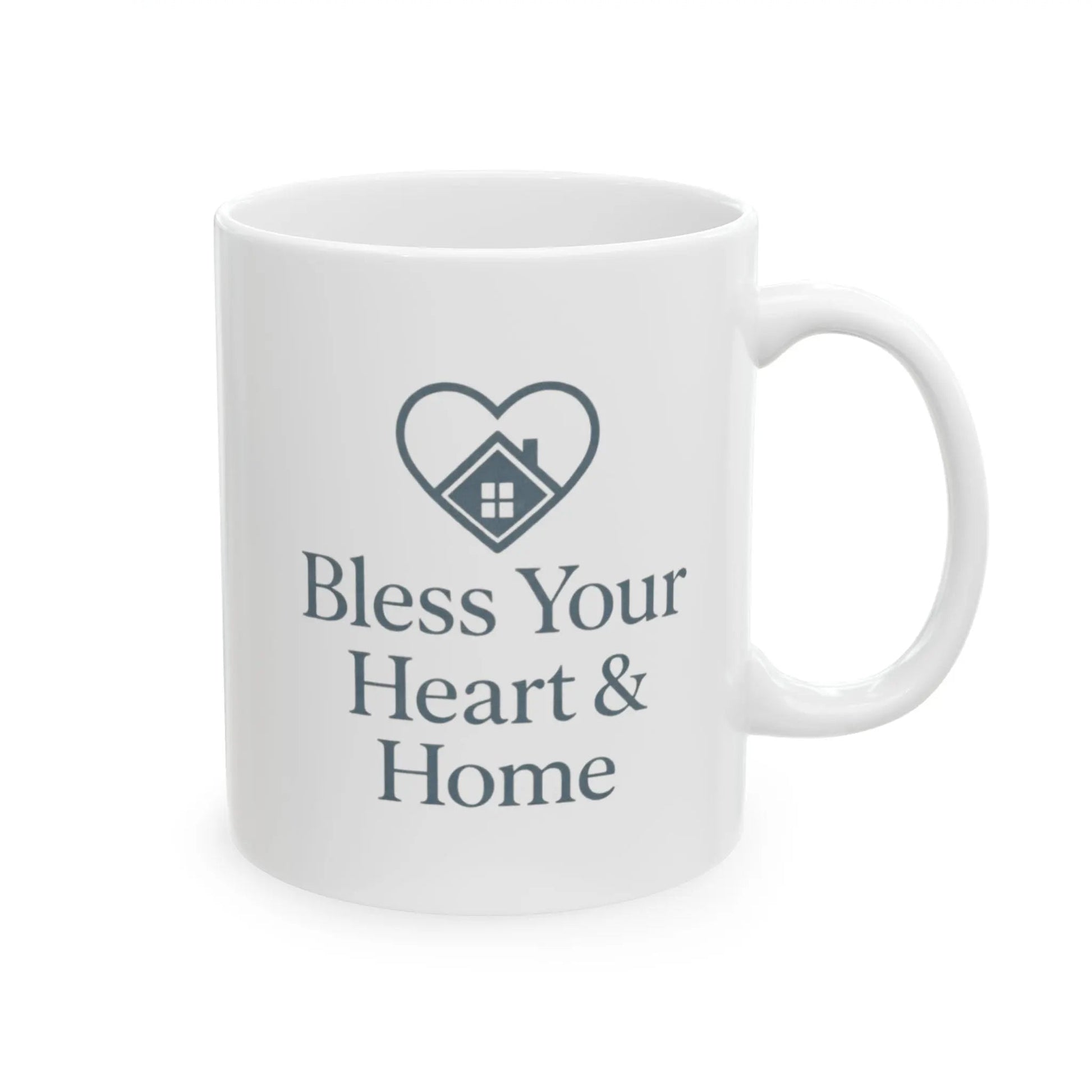 A white ceramic mug with a dark gray printed design featuring a heart outline containing a small house icon and the text 'Bless Your Heart & Home' on a clean white background.