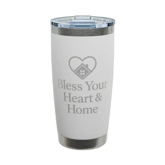 A white insulated tumbler with a clear lid, featuring a gray laser-engraved heart-with-house icon and the text 'Bless Your Heart & Home' on the front. The tumbler is shown on a clean white background with a subtle shadow.