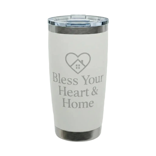 A white insulated tumbler with a clear lid and silver metal trim, featuring the text 'Bless Your Heart & Home' and a heart-shaped house graphic on the front. A small 'Comfort Colors' logo is visible in the top-left corner.