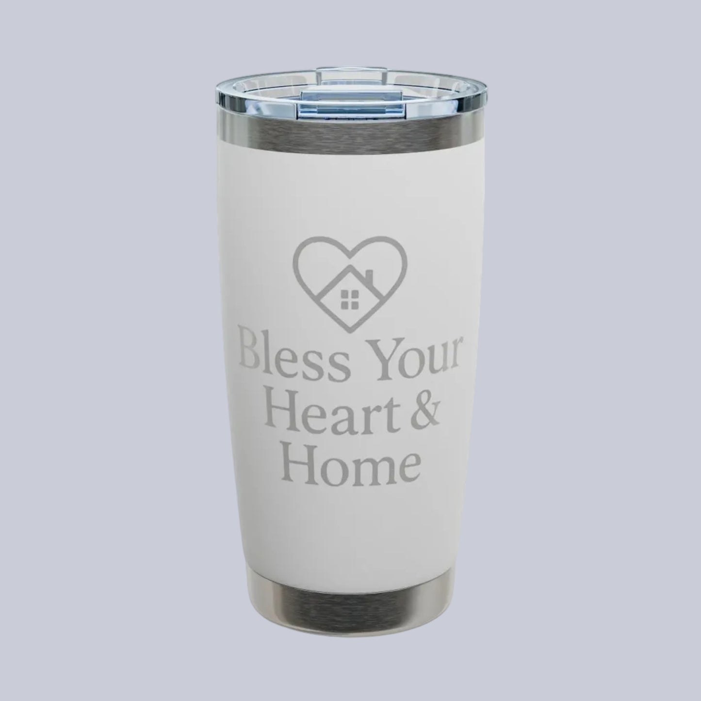 A white insulated tumbler with a clear lid and silver metal trim, featuring the text 'Bless Your Heart & Home' and a heart-shaped house graphic on the front. A small 'Comfort Colors' logo is visible in the top-left corner.