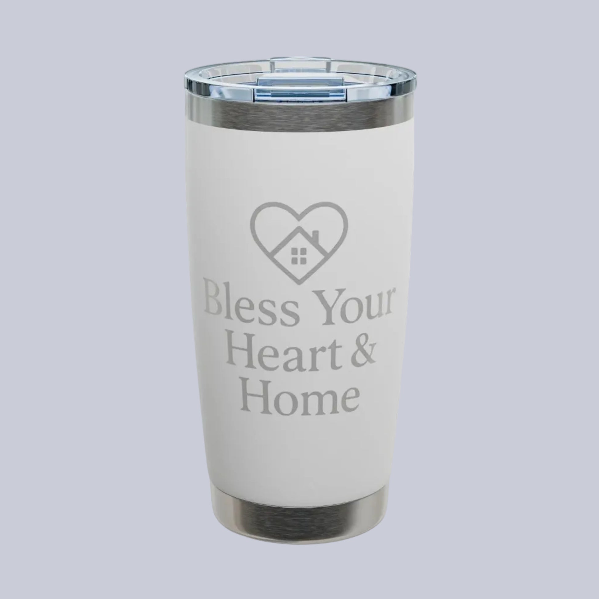 A white insulated tumbler with a clear lid and silver metal trim, featuring the text 'Bless Your Heart & Home' and a heart-shaped house graphic on the front. A small 'Comfort Colors' logo is visible in the top-left corner.
