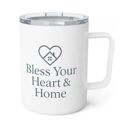 A white insulated travel mug with a clear lid, featuring a dark gray printed heart-shaped house icon and the text 'Bless Your Heart & Home' on the front. A small 'Comfort Colors' logo is visible in the top-left corner.