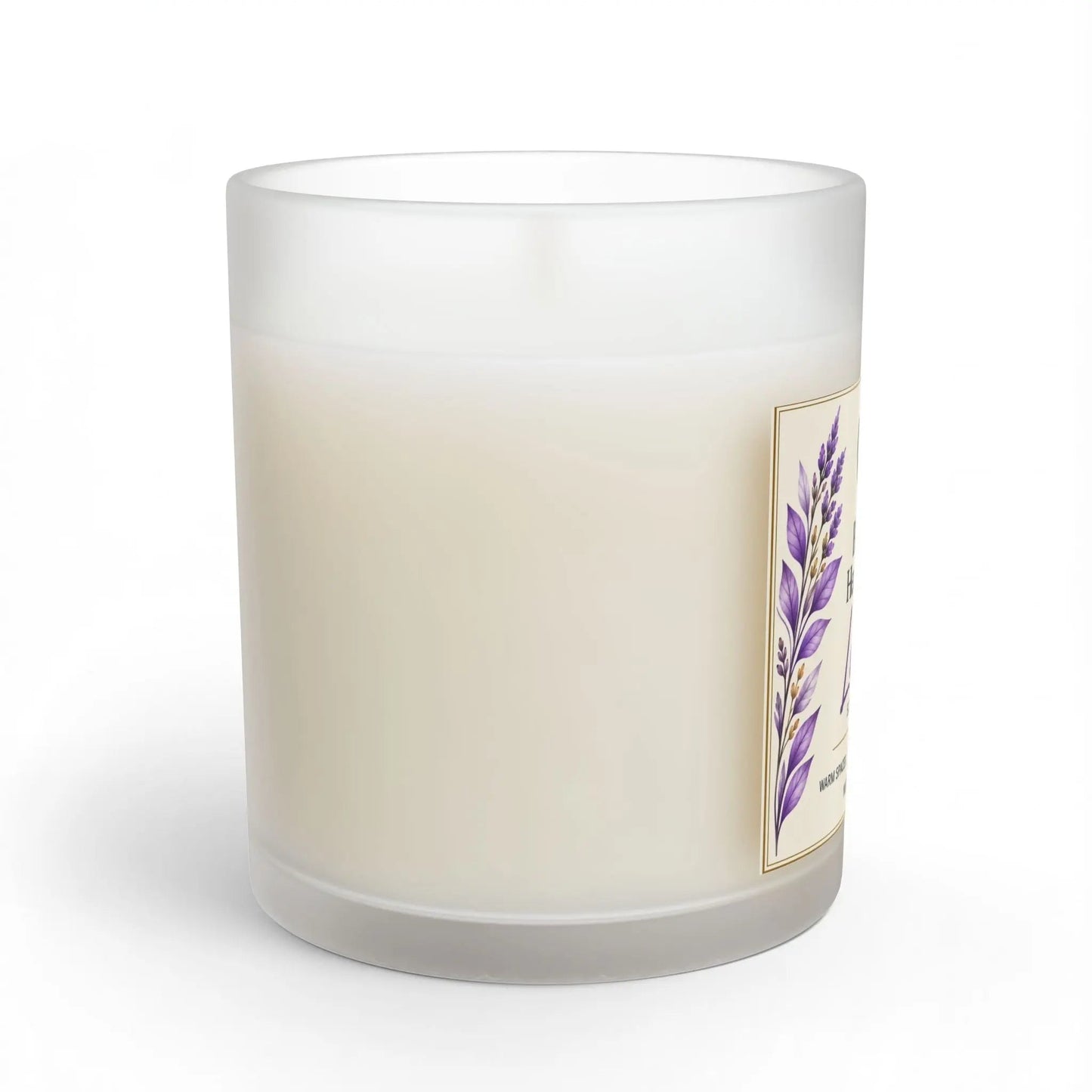 A frosted glass jar candle with creamy off-white wax, featuring a side label with a purple lavender illustration and gold border, set against a plain white background.