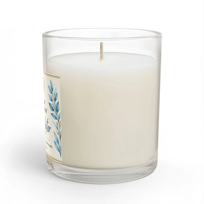 A white wax candle in a clear glass jar with a single wick, featuring a cream label with blue botanical leaf illustrations. The candle is photographed on a clean white background with a subtle shadow.