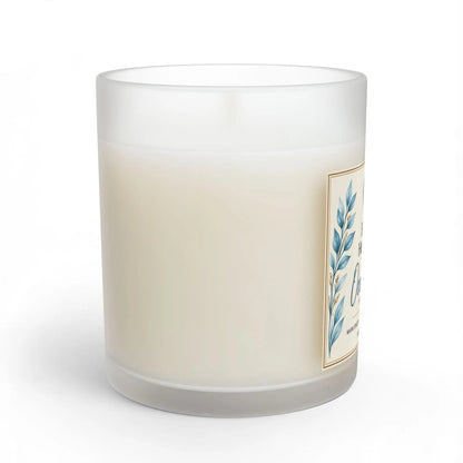 A frosted glass jar candle with creamy off-white wax, featuring a decorative label with blue botanical leaves and gold border details, shown on a clean white background.