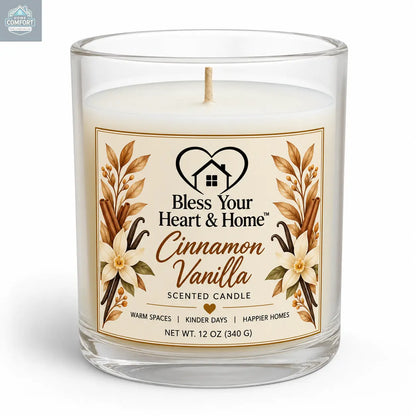 A 11 oz scented candle in a clear glass jar with a white wax fill and a cream-colored label. The label features gold wheat illustrations and the brand name 'Bless Your Heart & Home' with the scent 'Cinnamon Vanilla'.