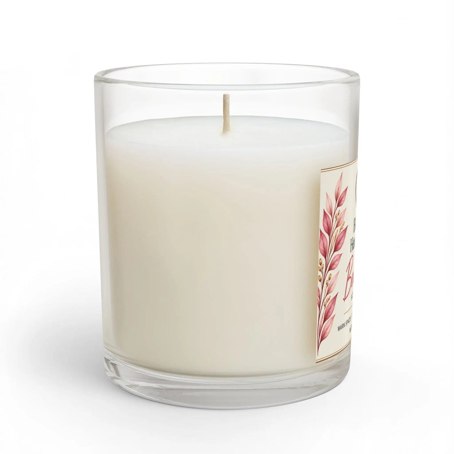 A white wax candle in a clear glass jar with a single wick and a decorative label featuring pink botanical leaves, shown on a clean white background.
