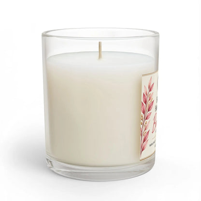 A white wax candle in a clear glass jar with a single wick and a decorative label featuring pink botanical leaves, shown on a clean white background.