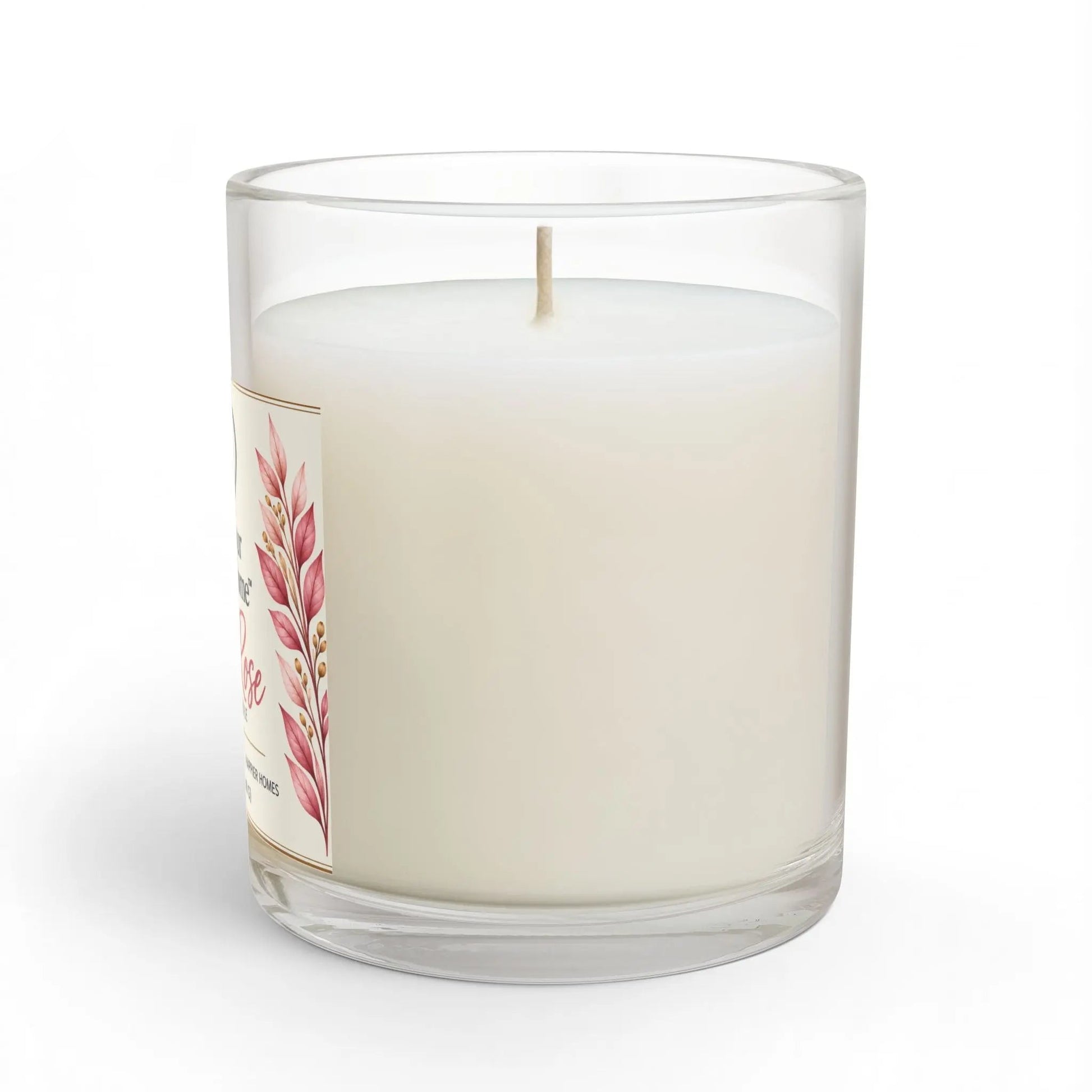 A white wax candle in a clear glass jar with a single wick, featuring a decorative label with pink botanical illustrations. The candle is photographed on a clean white background with a soft shadow.