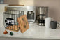 Coffee filter holder metal basket with wooden lid and coffee capsules on kitchen countertop
