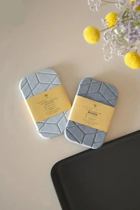 Geometric diatomite soap dish with quick-dry stone material shown packaged on bathroom counter