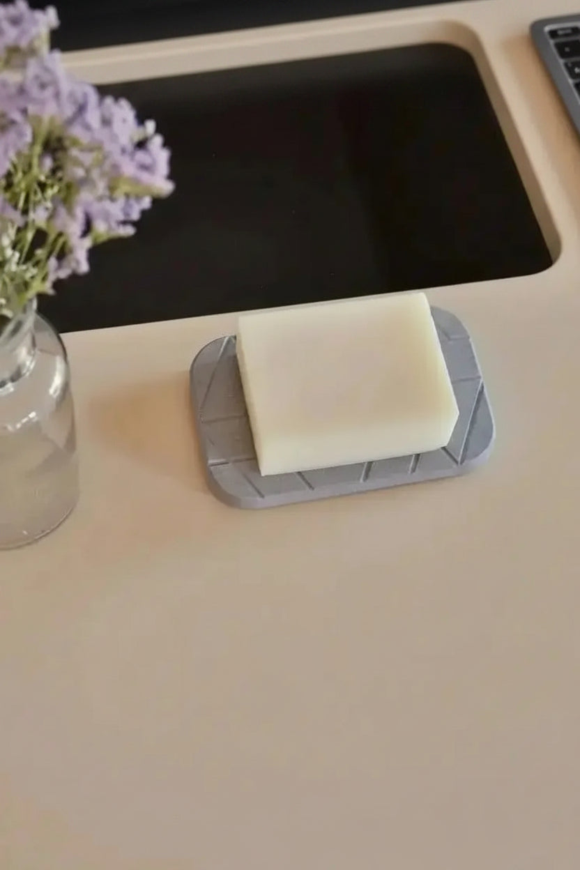 Modern geometric diatomite soap dish with bar soap placed beside bathroom sink