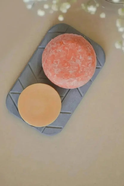 Quick-drying geometric diatomite soap dish holding two bar soaps on bathroom surface