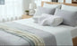 Orthopedic memory foam cervical pillow placed on a neatly made bed in a modern bedroom