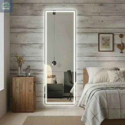 White full length LED mirror placed in bedroom showing illuminated frame and freestanding design
