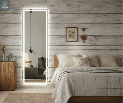 White full length LED mirror placed in bedroom showing illuminated frame and freestanding design