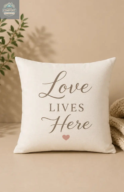 Decorative pillow with 'Love Lives Here' text on a beige background