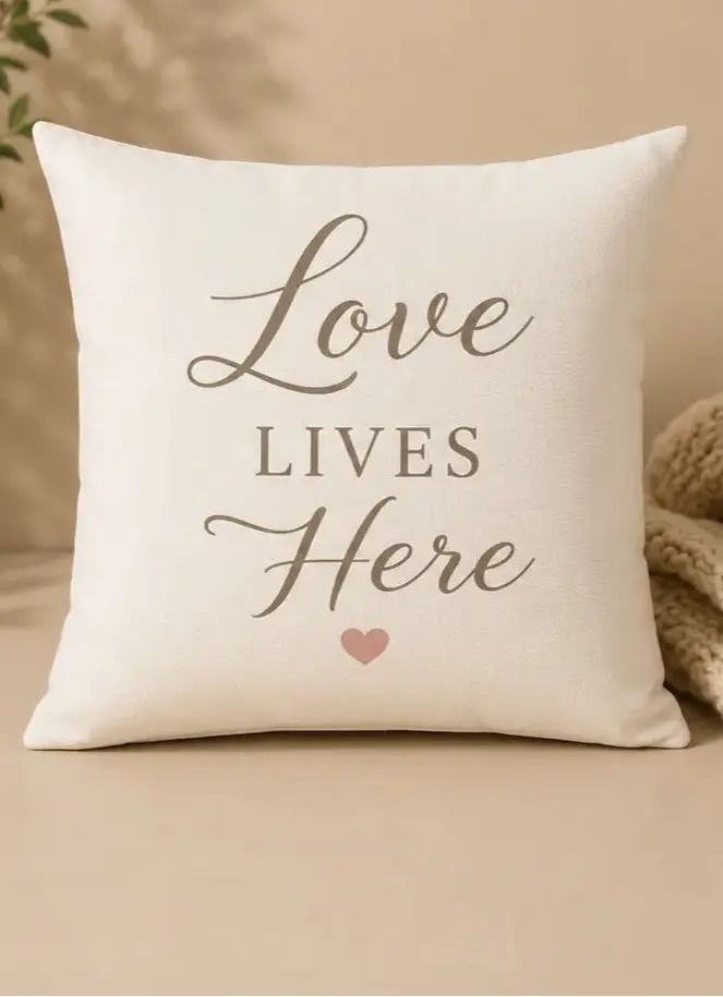 Decorative pillow with 'Love Lives Here' text on a beige background