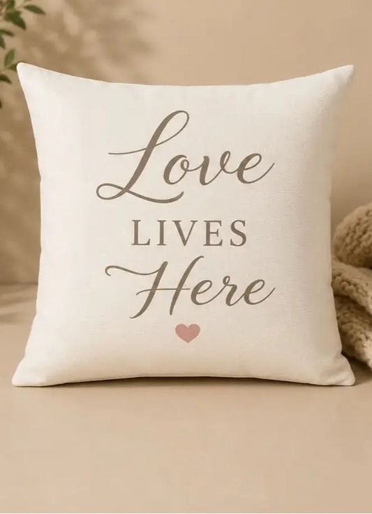 Decorative pillow with 'Love Lives Here' text on a beige background