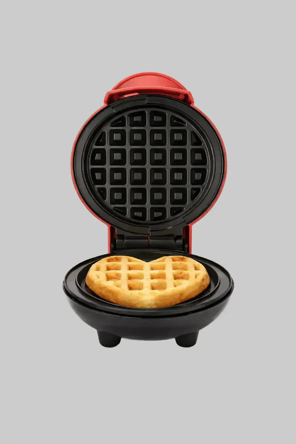 Compact mini waffle maker open with freshly cooked waffle inside on a clean white background.